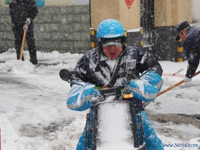 外卖小哥暴雪中自便前行送餐 湿滑路面艰巨骑行